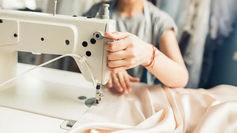Costureira confeccionando uniforme na máquina de costura